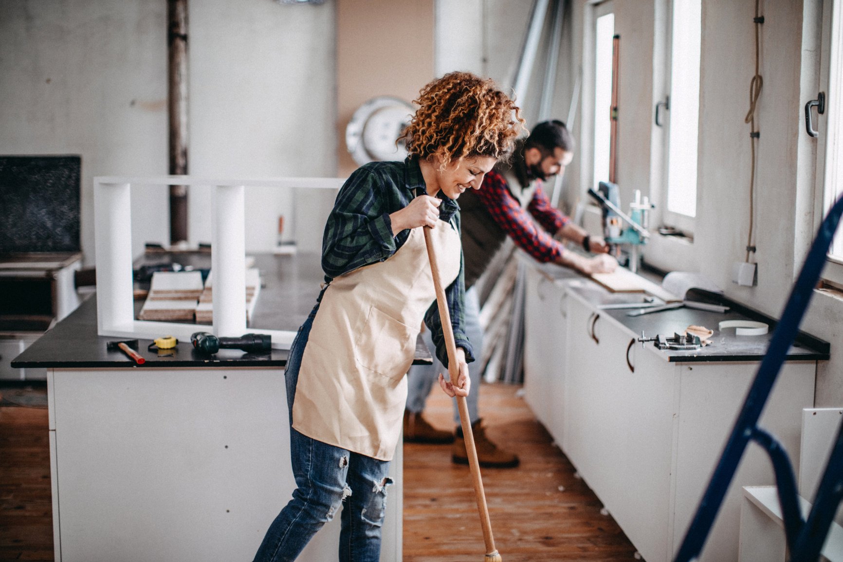 Young couple cleaning a construction workshop